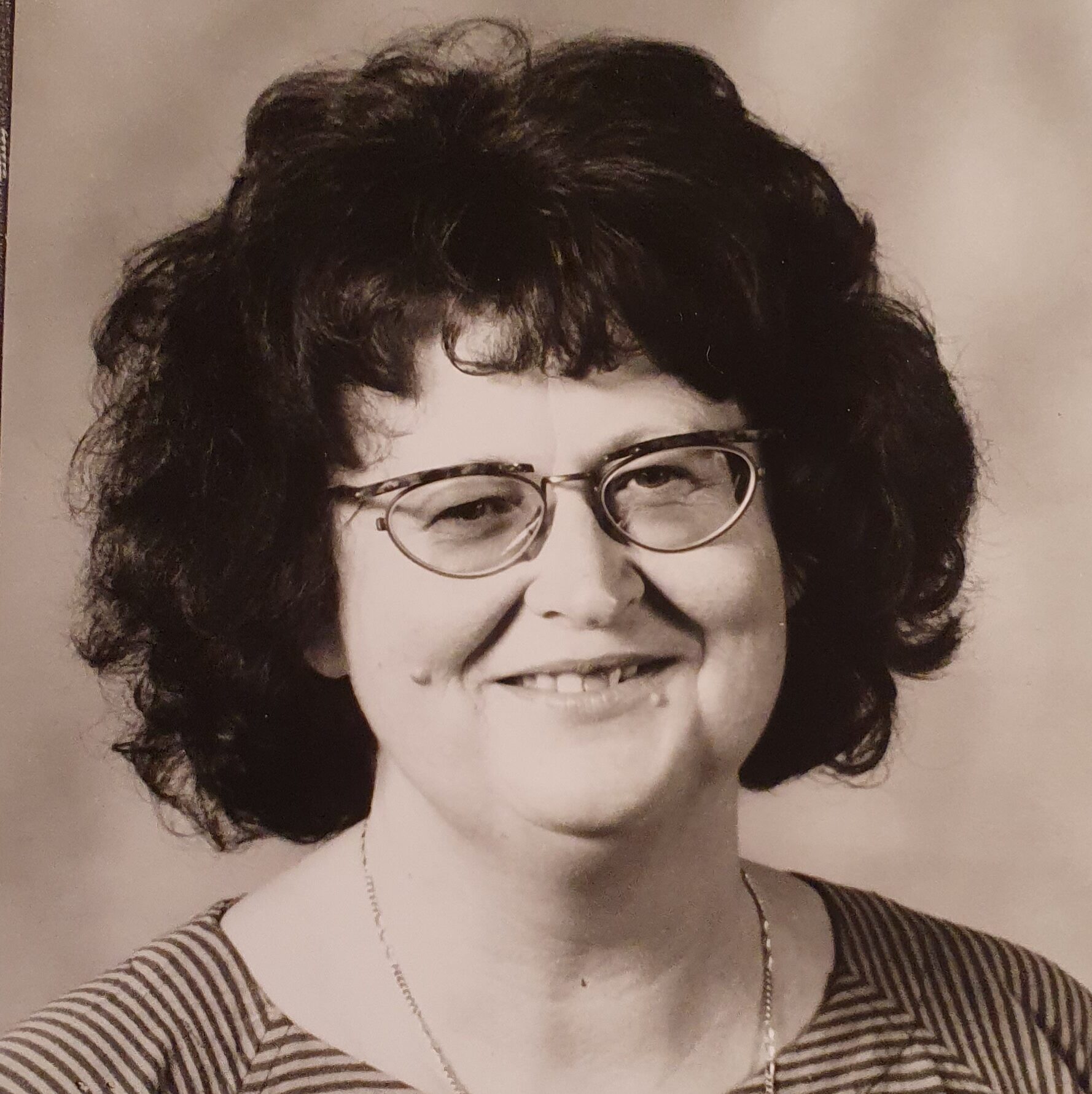 Ein Schwarz-Weiß-Foto zeigt eine Frau mit fülligem dunklem Haar und Brille.