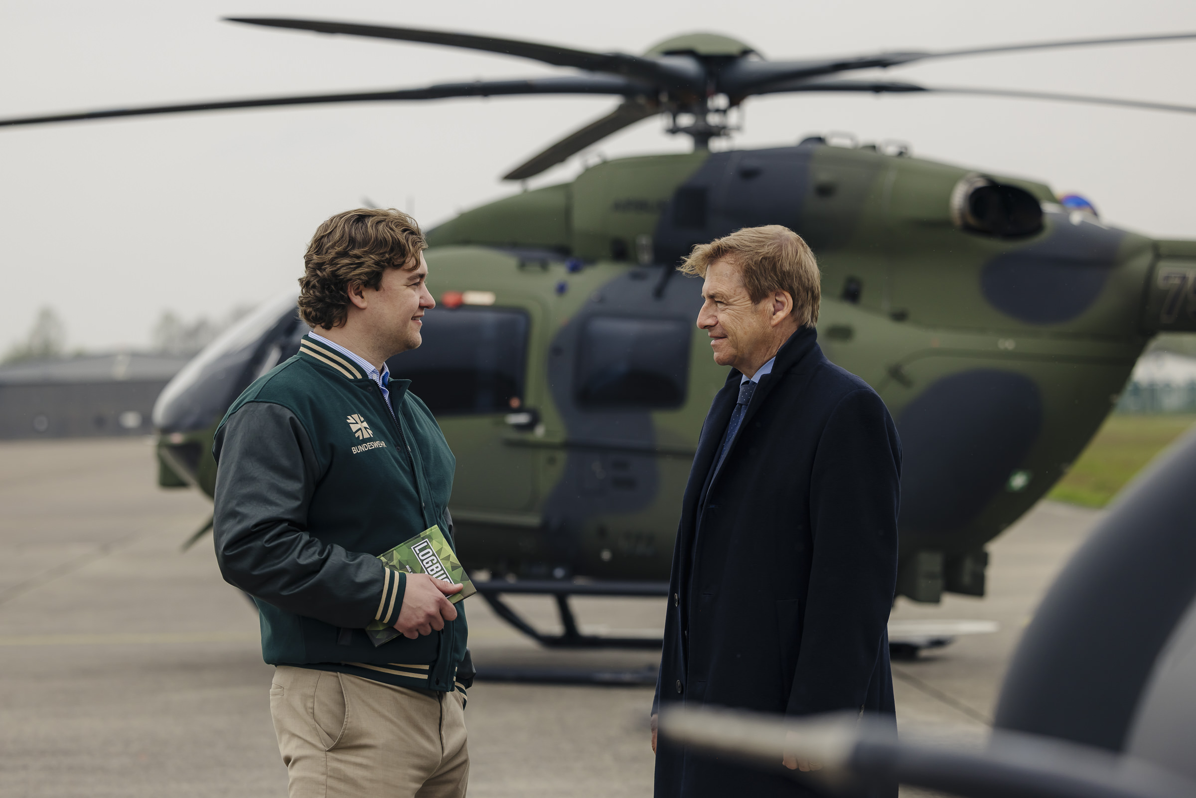 Maximilian H. und Volker Schmidt unterhalten sich vor einem Militärhubschrauber