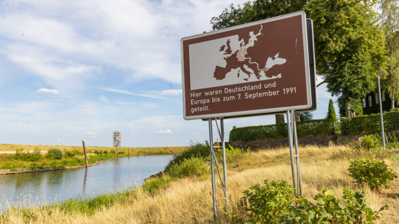 Foto zeigt Hinweisschild auf ehemalige Grenze an einem Fluss