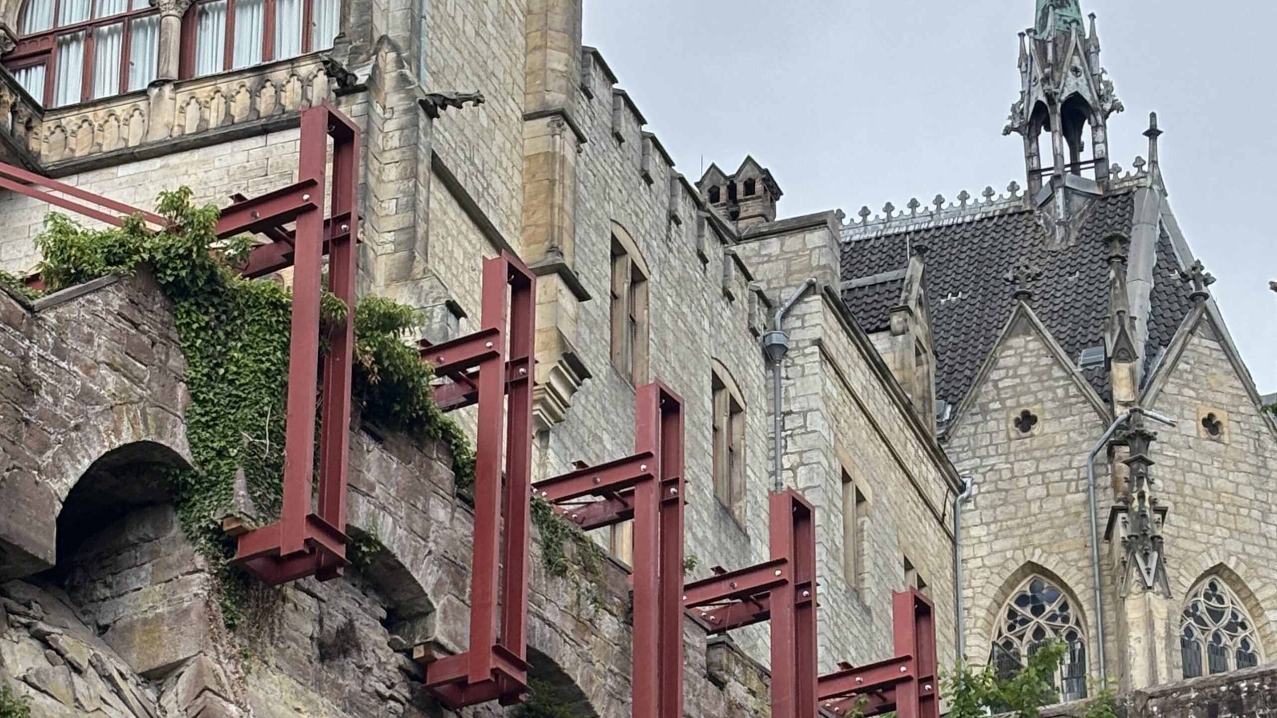 Große rote Stahlbalken, die unter das Mauerwerk des Laubengangs der Marienburg greifen