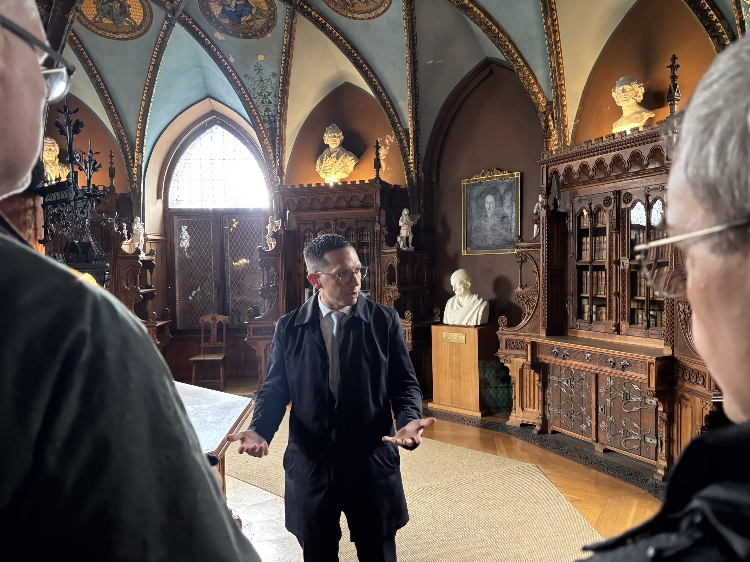 Minister Mohrs steht in einem prunkvollen Raum der Marienburg und gestikuliert vor Reportern