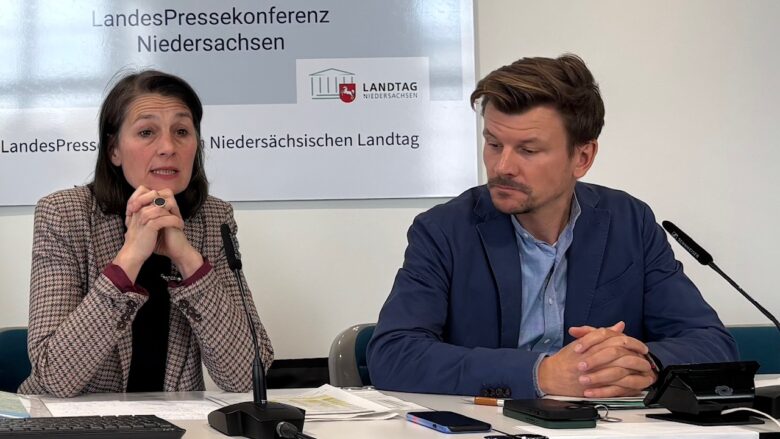 Eine Frau und ein Mann in förmlicher Kleidung sitzen auf dem Podium der Landespressekonferenz.