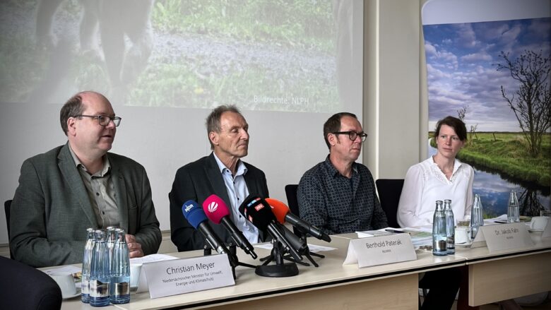 Foto zeigt Minister Meyer und NLWKN-Mitarbeiter am Tisch sitzend