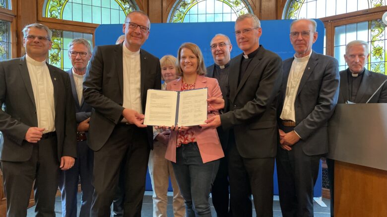 Foto zeigt Kultusministerin und Bischöfe mit unterschirebenem Dokument