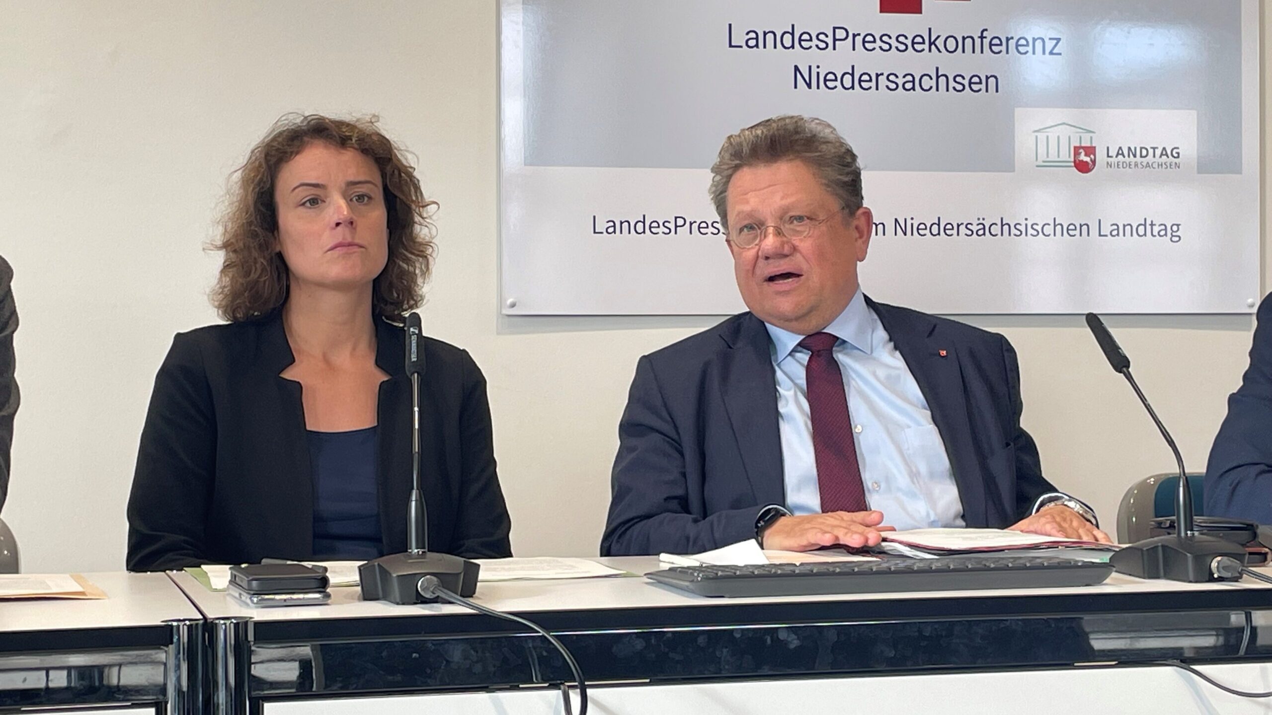 Das Foto zeigt eine Frau und einen Mann auf dem Podium der Landespressekonferenz.