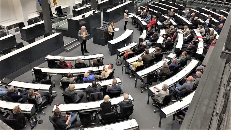 Ein Foto zeigt das Forum des Landtages bei einer Veranstaltung von der Pressetribüne aus. Mehr als die Hälfte der Plätze sind belegt.