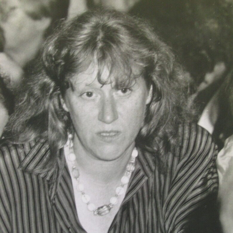 Ein Schwarz-Weiß-Foto zeigt eine Frau mit wuscheligem Haar und ernstem Gesicht.